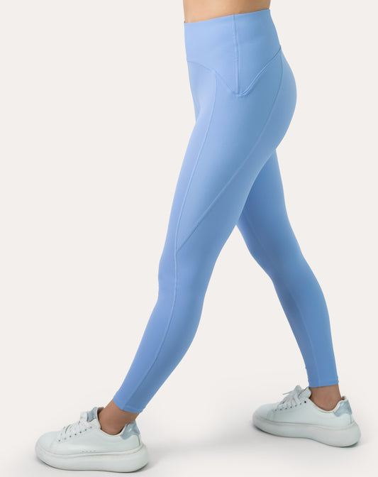 Light blue seamless gym leggings with V-contour high waistband; left three quarter step view