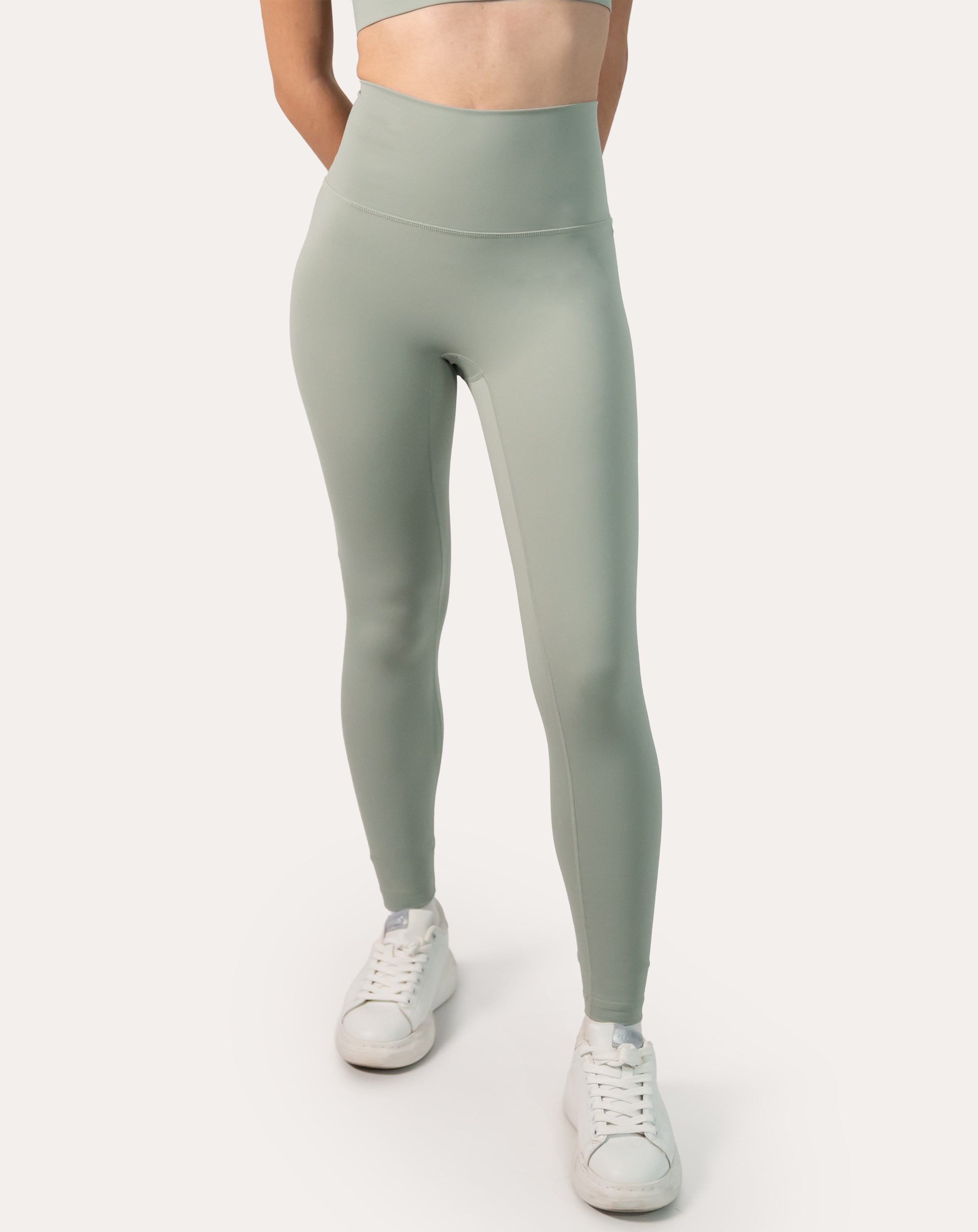 Full-length front shot of women’s seamless leggings in soft sage green; supportive high-waist and clean, second-skin look