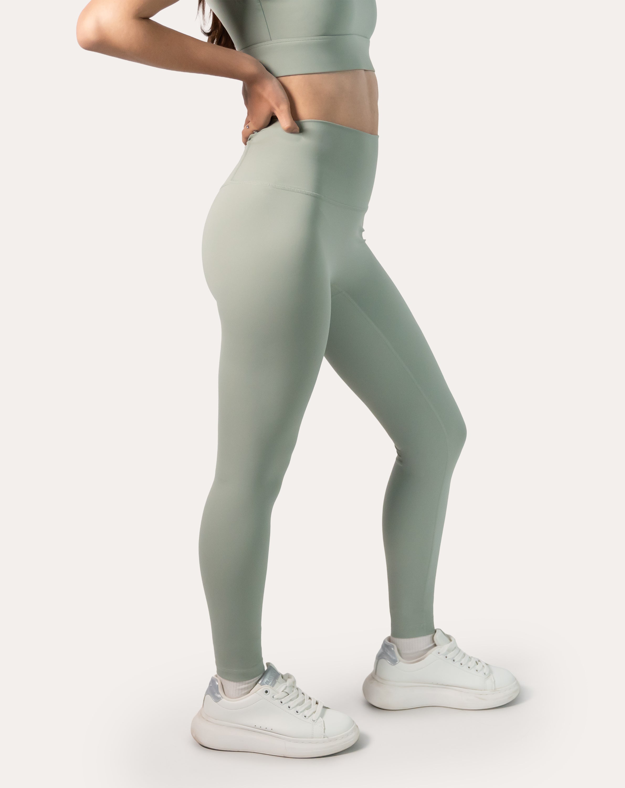 Side profile highlighting stretch and smooth finish of high-waisted seamless leggings in sage green