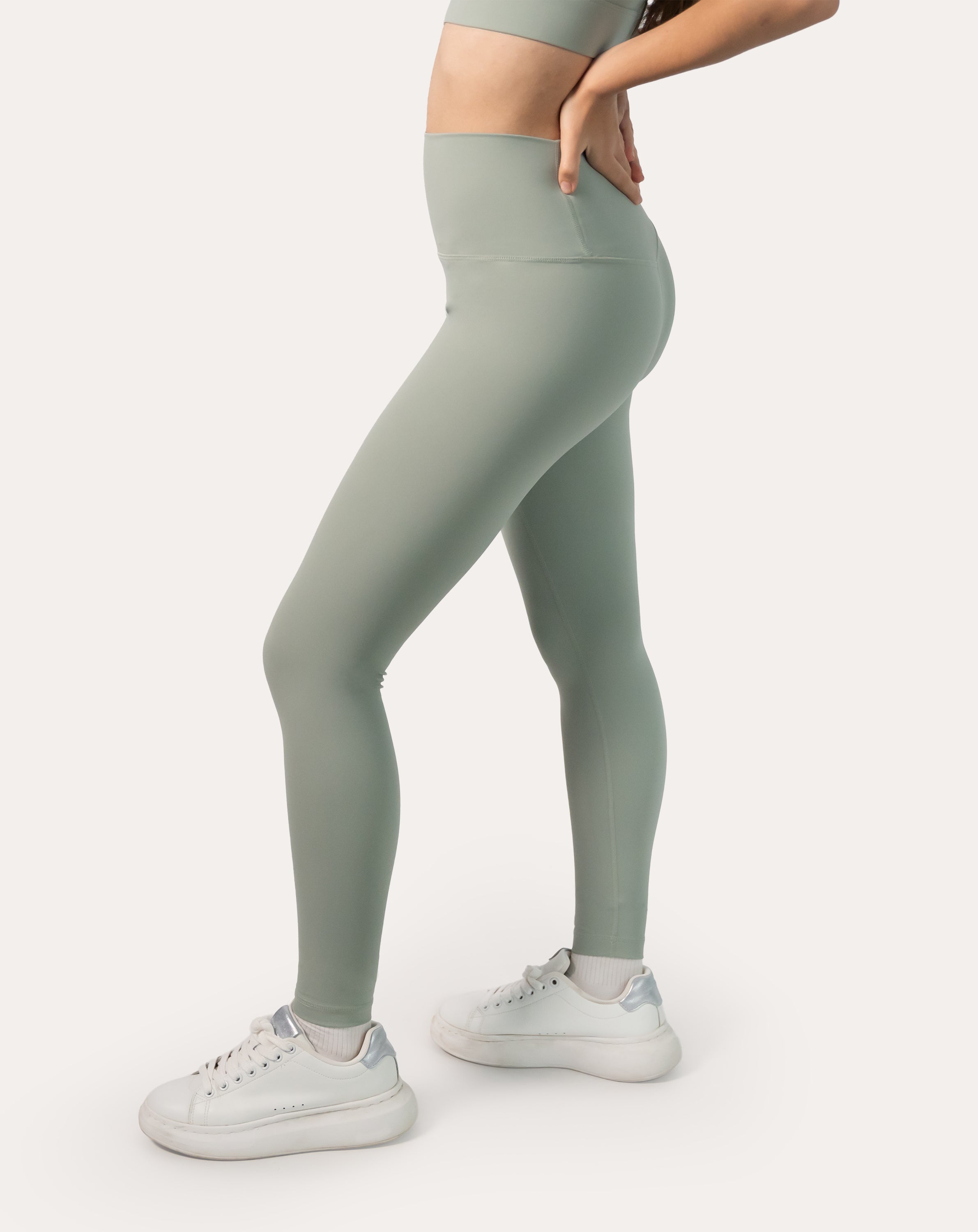 Back-angle full-body view of the sage green seamless leggings set showing supportive waistband and smooth, squat-proof fabric
