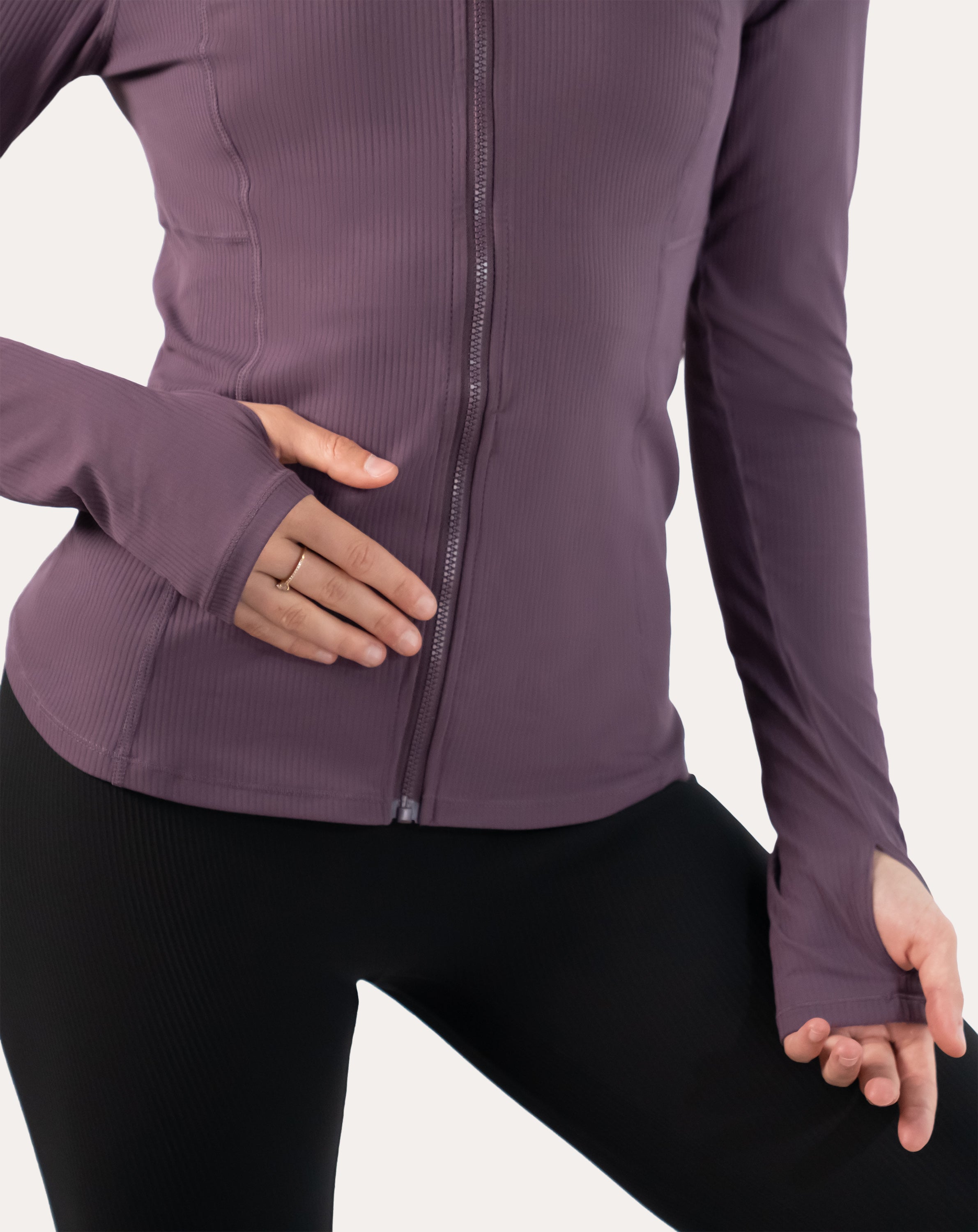 Front detail of slate-lavender women’s training jacket highlighting thumbhole cuffs and sleeve fit