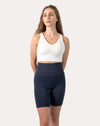 Full-length front view of white backless sports bra with smooth V-neck and longline underband