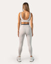 Back view of white gym set for women highlighting deep U-back with clasp closure