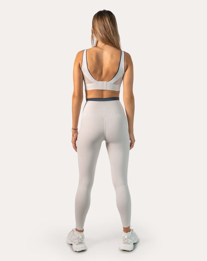 Back view of white gym set for women highlighting deep U-back with clasp closure