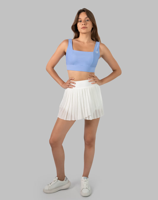 Full-body front view of white pleated wrap gym skirt with A-line silhouette