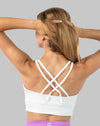 Back view with arms raised highlighting crisscross straps and wide underband.