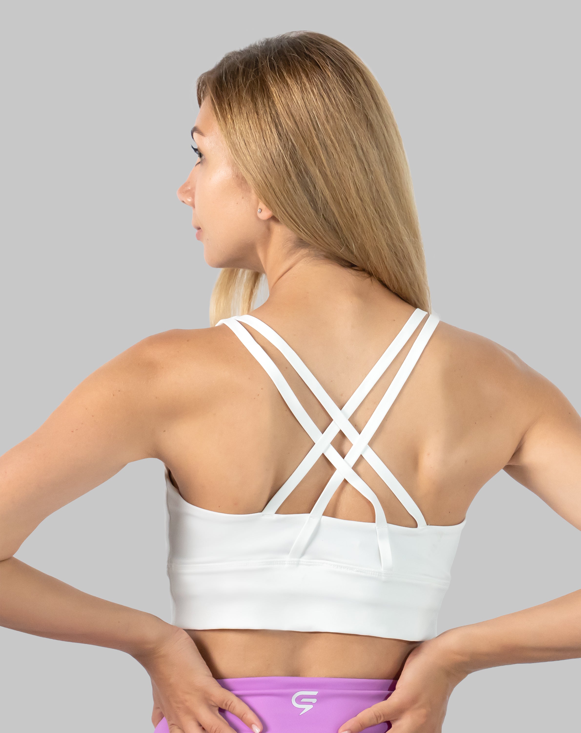 Left back three-quarter view of white medium support sports bra with X-back straps