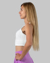 Right side profile of white medium support sports bra showing wide underband and wireless fit