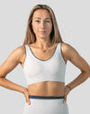 White seamless sports bra, straight front mid-length view with wide straps and longline band