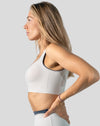 White seamless sports bra side profile highlighting wide straps and supportive underband