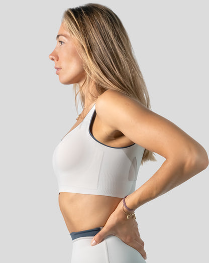 White seamless sports bra side profile highlighting wide straps and supportive underband