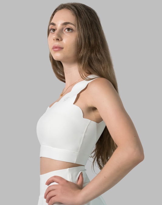 Left side profile of white sports bra showing single strap and cropped hem
