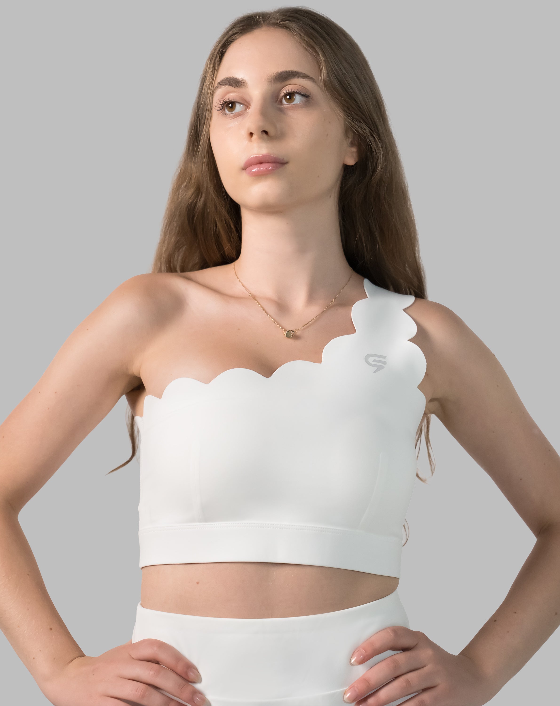 White sports bra with one-shoulder scalloped neckline, front three-quarter view