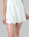 Front close-up of white tennis skirt highlighting scalloped hem and A-line drape