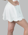 Side close-up of white tennis skirt showing scalloped hem and smooth knit