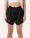 Front close-up of black women's 2-in-1 running shorts with elastic waistband and curved split hem