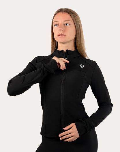 Women’s black gym jacket in a slim fit with thumbholes, front-left three-quarter view while zipping the collar