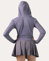 Back view of the lavender women’s fitness jacket with hood up and hands on hips