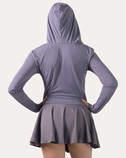Back view of the lavender women’s fitness jacket with hood up and hands on hips