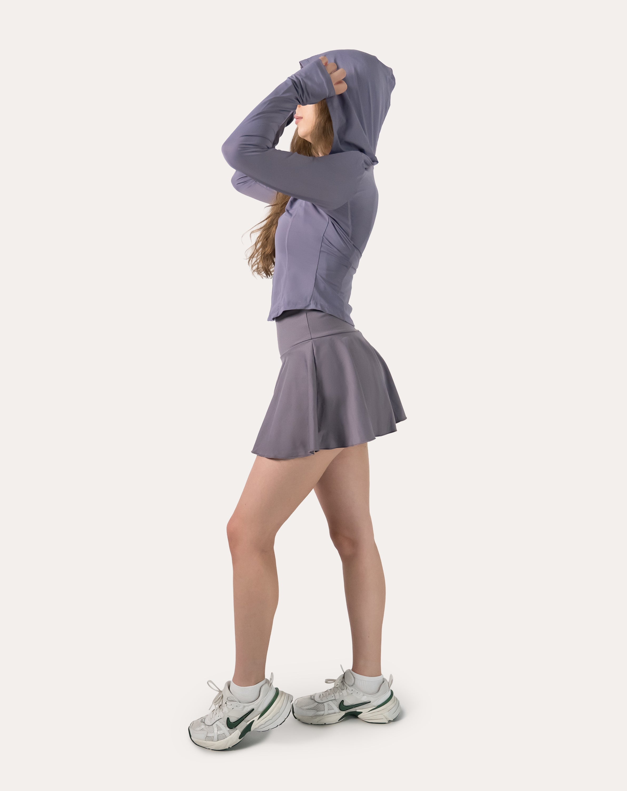 Right three-quarter view of the lavender fitness jacket with arm raised to stretch