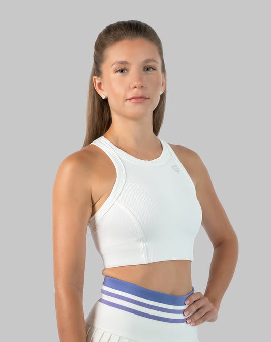 Model wearing a white ribbed gym crop top with high neckline; front three-quarter view showing cropped fit and racerback style