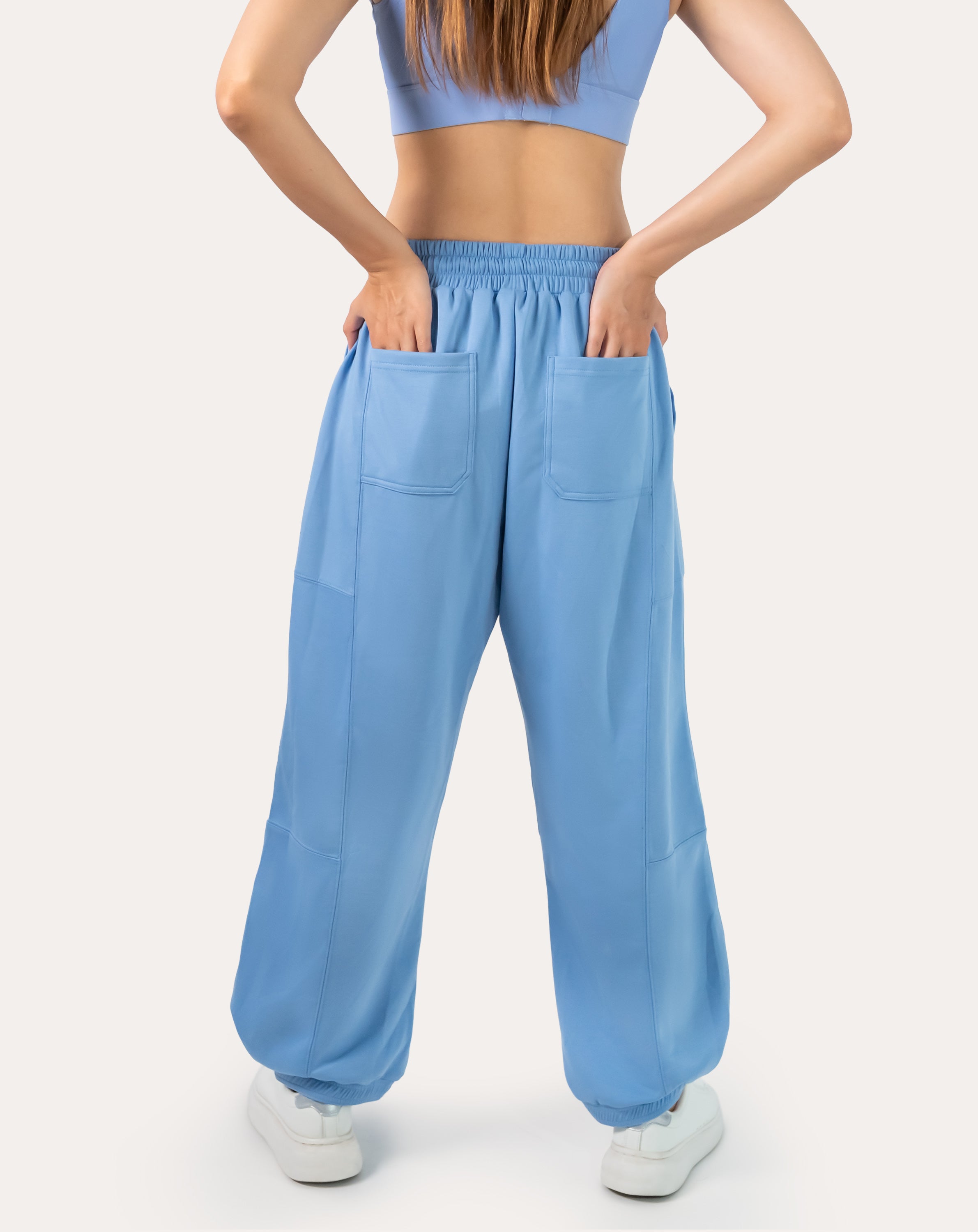 Sky-blue women’s gym joggers, full-body back view with cuffed ankles and relaxed fit