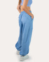 Left three-quarter walking pose in sky blue women’s gym joggers with relaxed, baggy cut