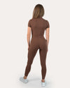 Straight back view of the brown women’s gym jumpsuit with arms relaxed