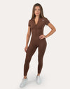Front view of the brown women’s gym jumpsuit with hands on hips