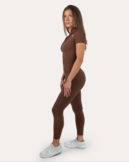 Brown women’s gym jumpsuit, right three-quarter view with hands on hips