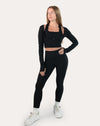 Front full-length view of black long sleeve gym top womens showing cropped silhouette and thumbholes
