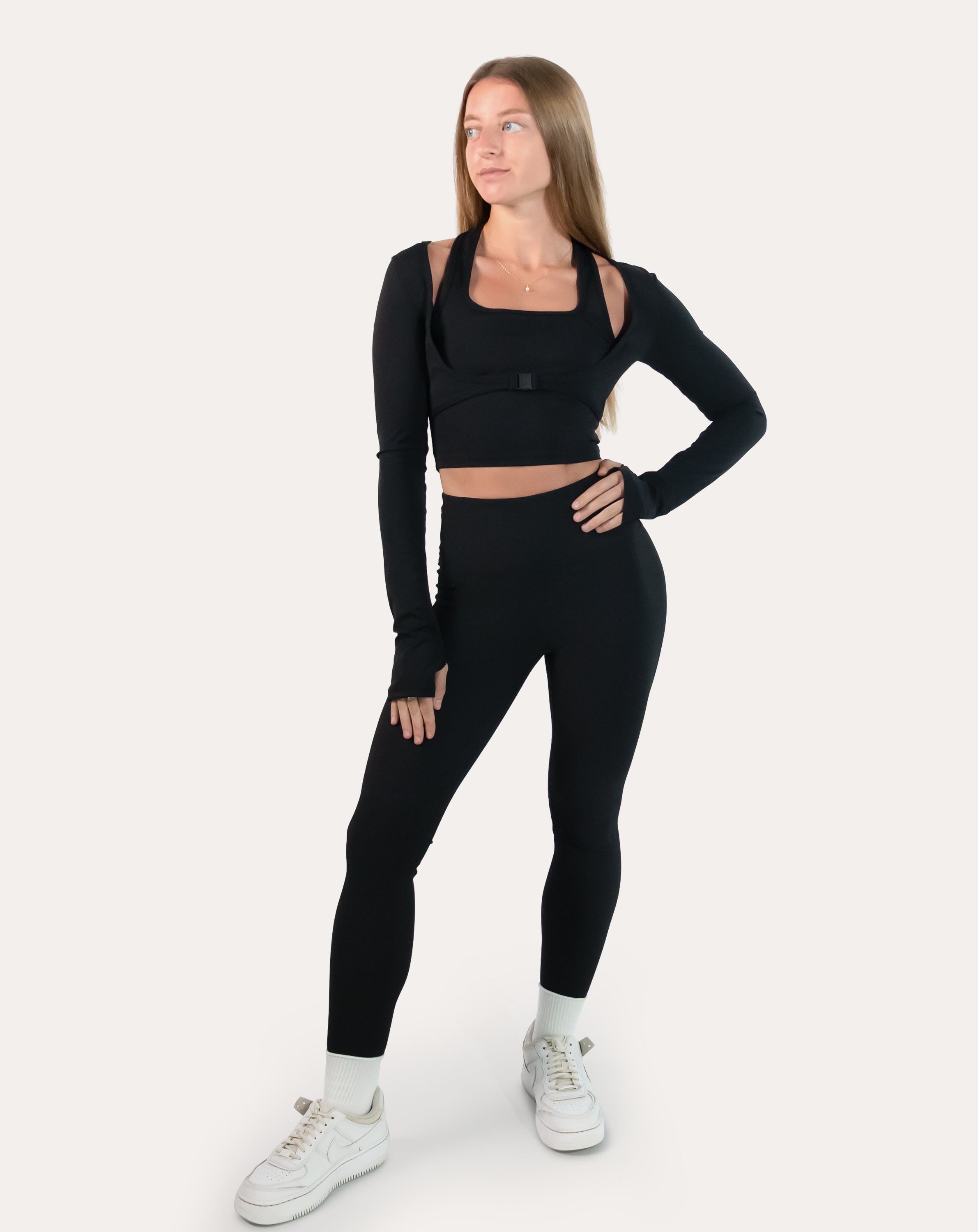 Front full-length view of black long sleeve gym top womens showing cropped silhouette and thumbholes