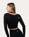 Side-back profile of black long sleeve gym top womens highlighting streamlined seams
