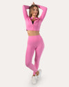 Full-length front view of the women’s pink cropped zip-up jacket, arms raised to show cropped length