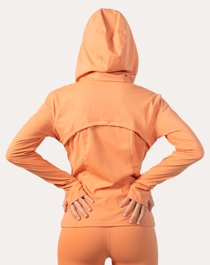 Back view of apricot women’s zip-up jacket with hood up and vented back yoke