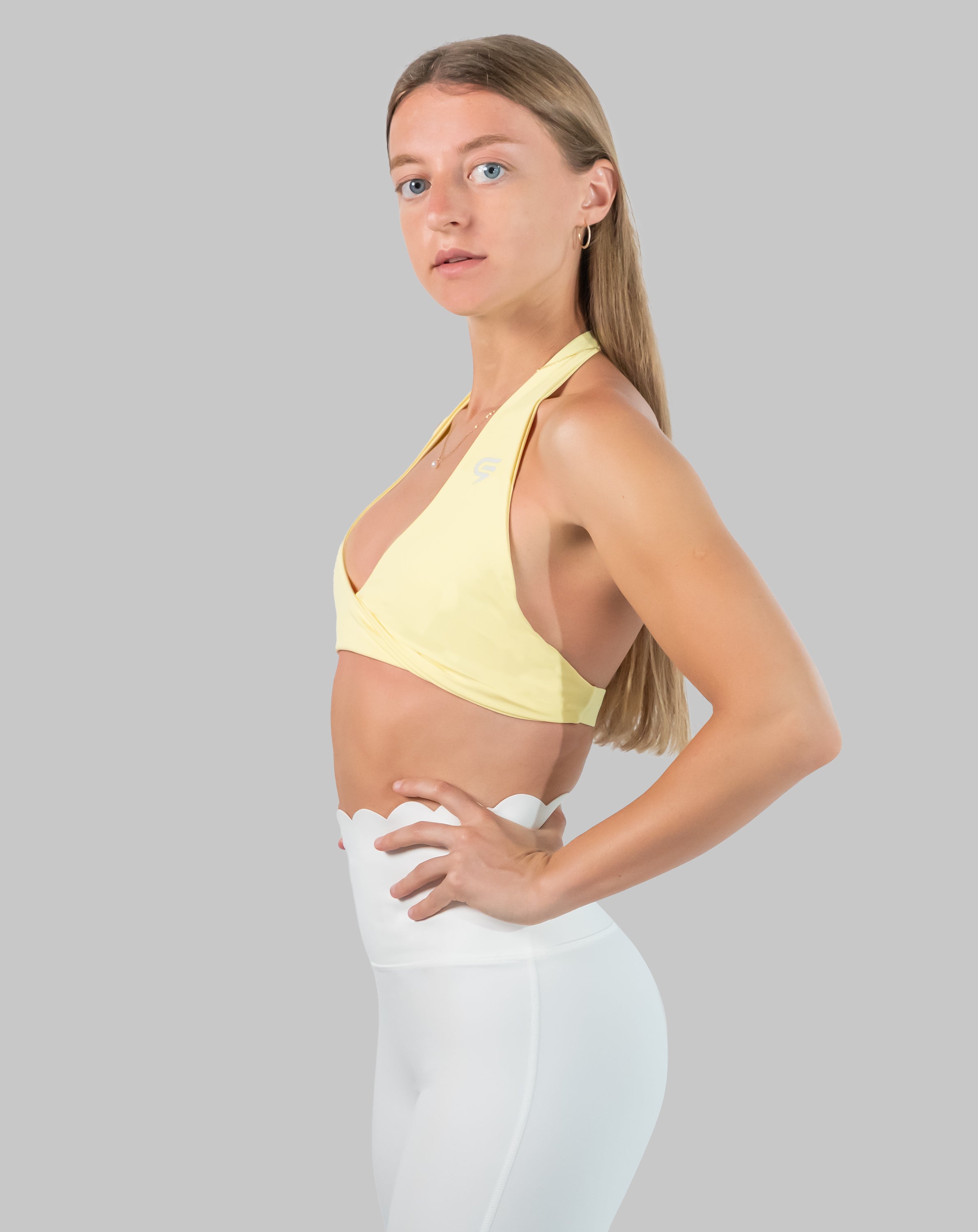 Yellow halter neck sports bra in three-quarter front pose with soft halter strap