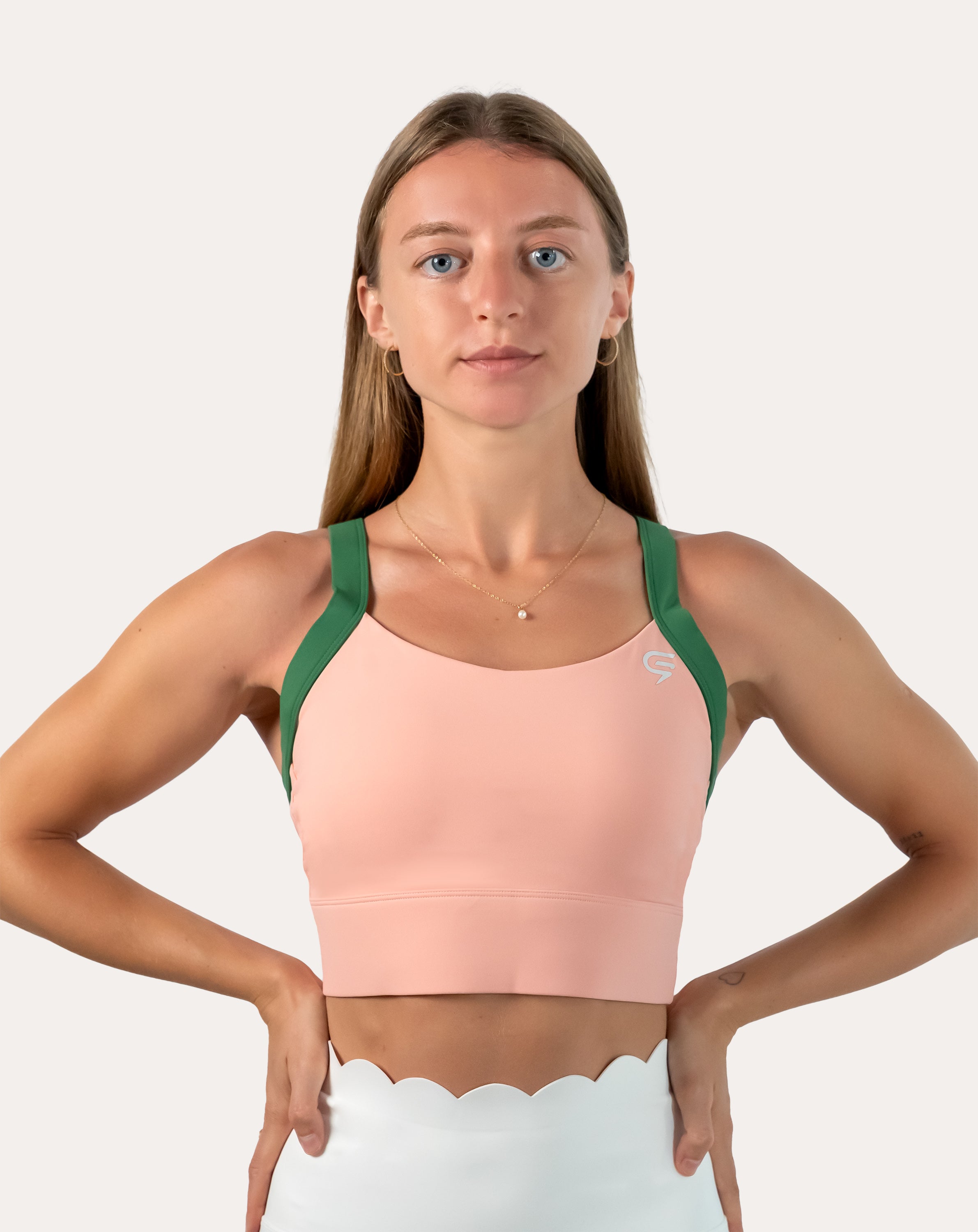 Straight front view of peach and green yoga sports bra with smooth scoop neckline