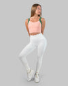Full-length front view of peach and green yoga sports bra styled with leggings