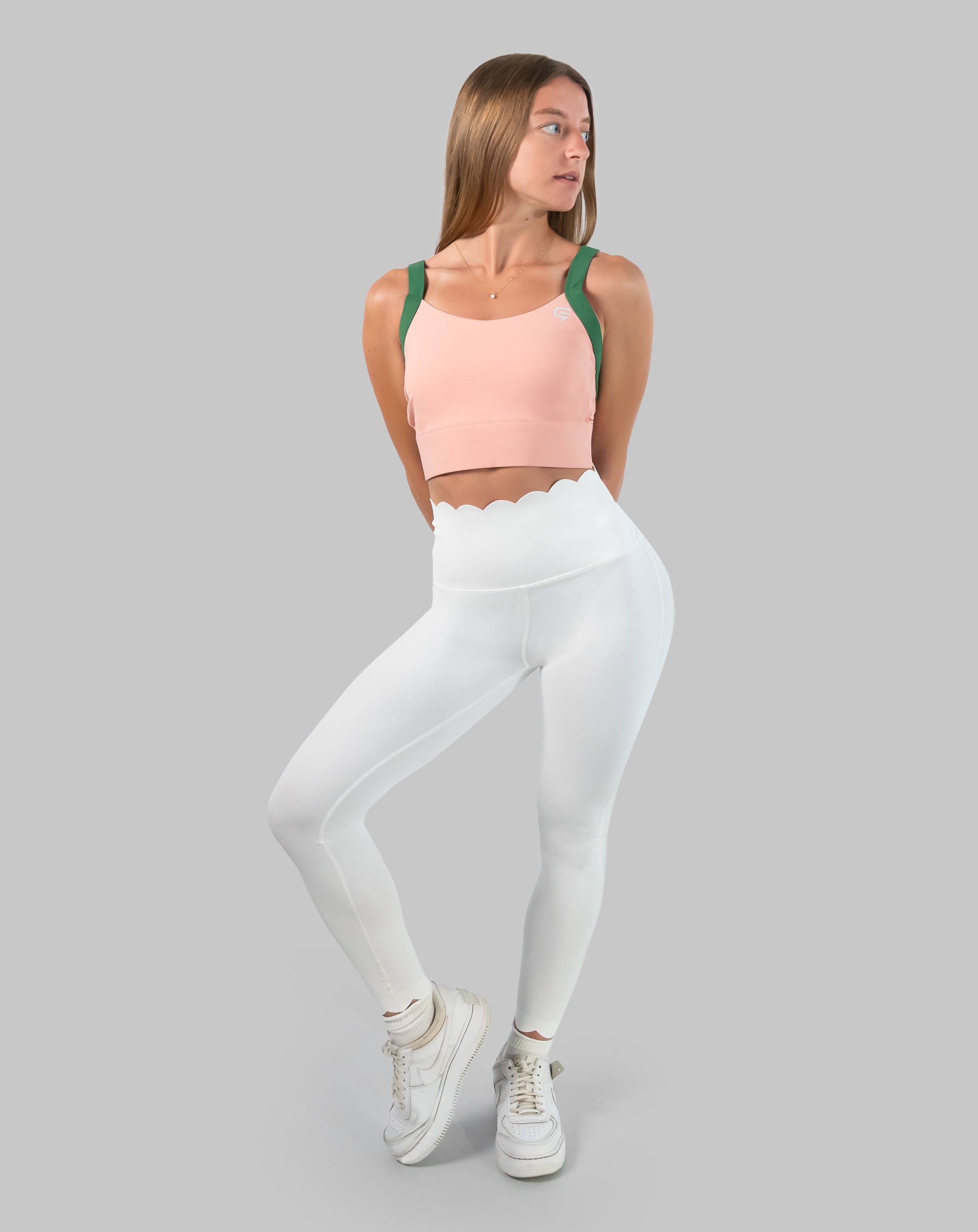 Full-length front view of peach and green yoga sports bra styled with leggings